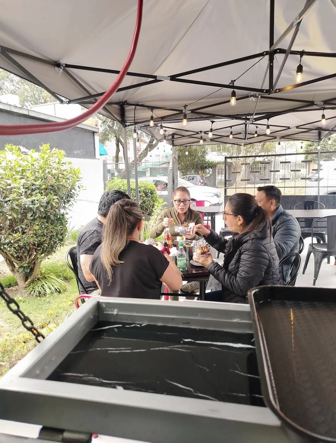 Un grupo compartiendo hamburguesas en el patio del restaurante